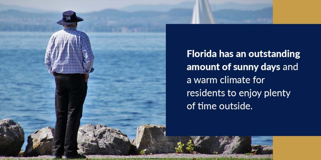 Man standing by the water wearing a hat, plaid shirt and dress pants.