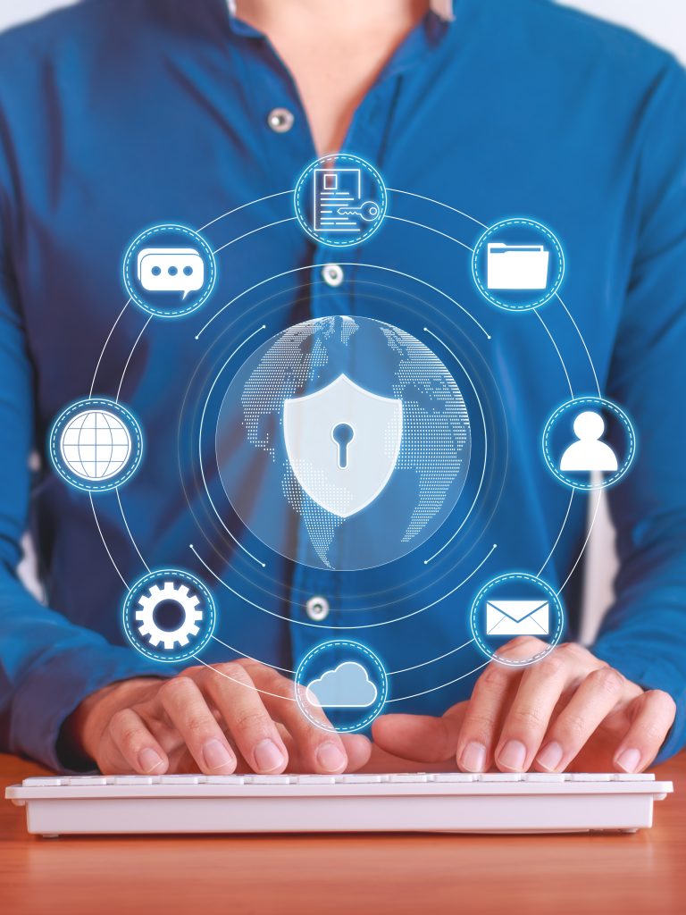 Person holding shield icon on a touchscreen representing cyber security protection for digital financial assets