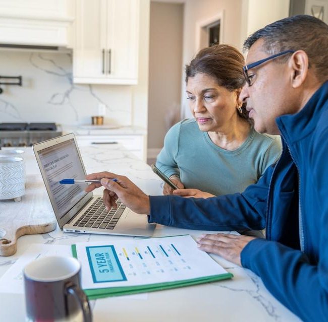 Retired couple meeting with financial advisor to discuss retirement income planning and investment withdrawal strategies