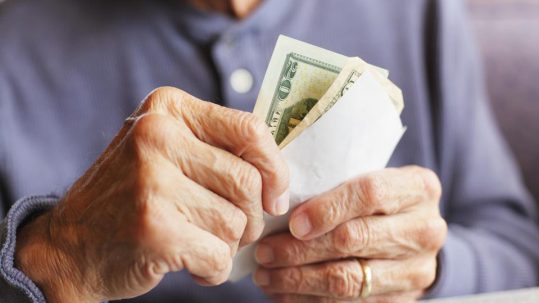 Retired couple reviewing cash reserves and retirement income strategy with financial advisor