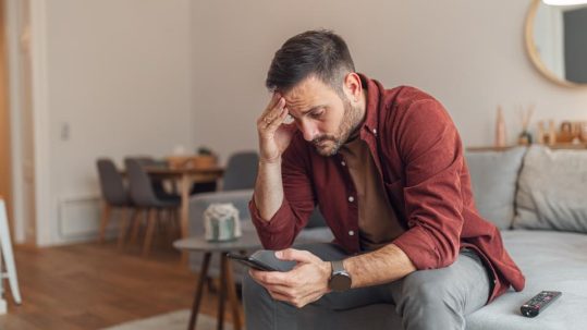 Person reviewing suspicious text message while learning how to avoid text scams and identity theft