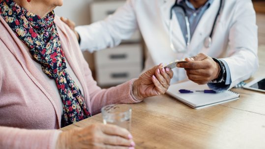Retired couple reviewing Medicare options and healthcare costs with a financial advisor.