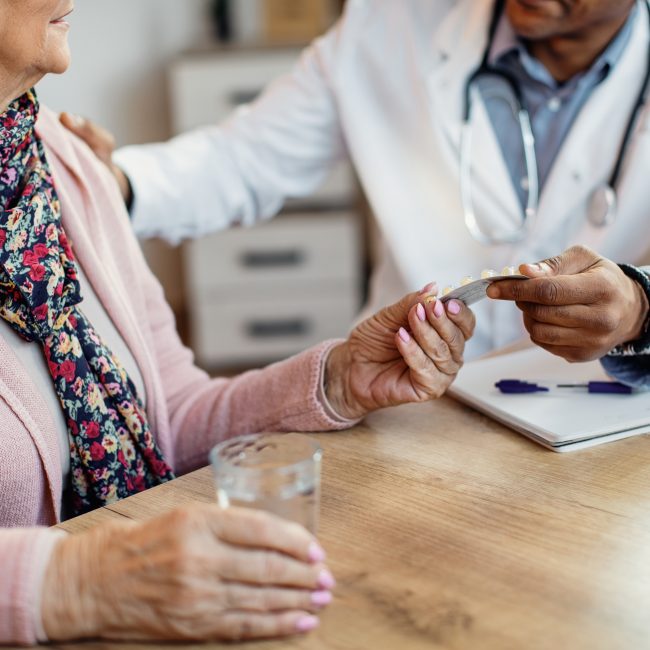 Retired couple reviewing Medicare options and healthcare costs with a financial advisor.
