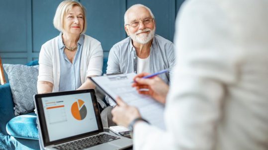 Couple reviewing estate planning documents with a financial advisor.