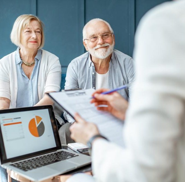 Couple reviewing estate planning documents with a financial advisor.