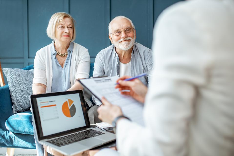 Couple reviewing estate planning documents with a financial advisor.