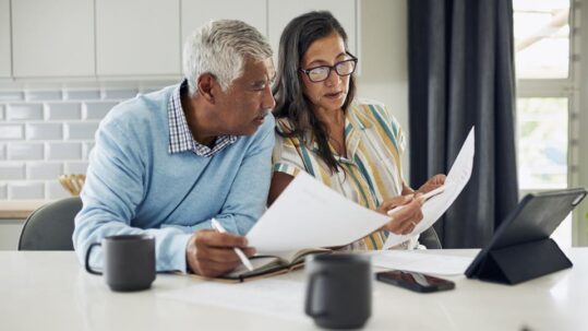 Retired couple comparing Social Security claiming ages 62, full retirement age, and 70