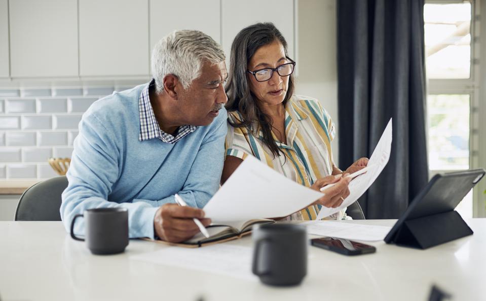 Retired couple comparing Social Security claiming ages 62, full retirement age, and 70