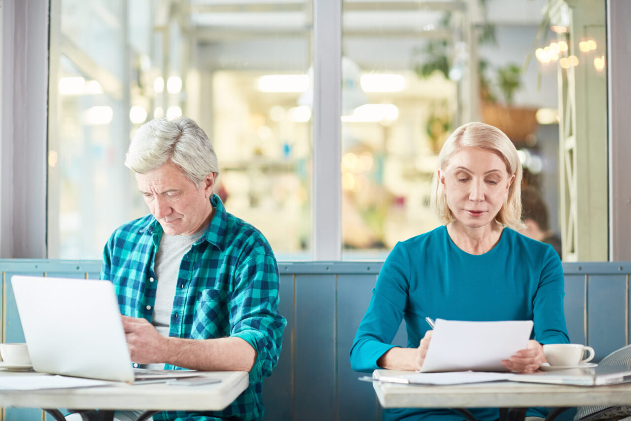Older adults working on a laptop and reviewing paperwork, illustrating working in retirement and the Social Security earnings test.