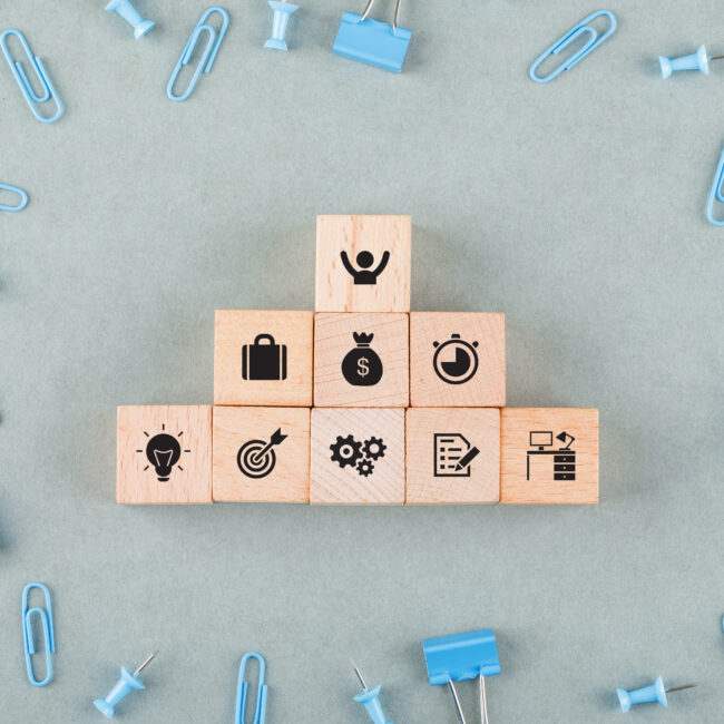 Wooden blocks with business icons representing tax-efficient employee benefits, retirement plans, and financial planning for small businesses