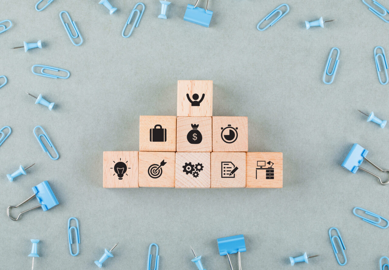 Wooden blocks with business icons representing tax-efficient employee benefits, retirement plans, and financial planning for small businesses