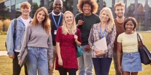Group Of University Or College Students With Tutors Outdoors On Campus Smiling And Looking At Camera