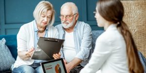 Senior couple with sad emotions during the meeting with financial consultant, signing some agreement in the office