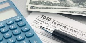 Tax concept. Tax form, calculator, money and pen on table